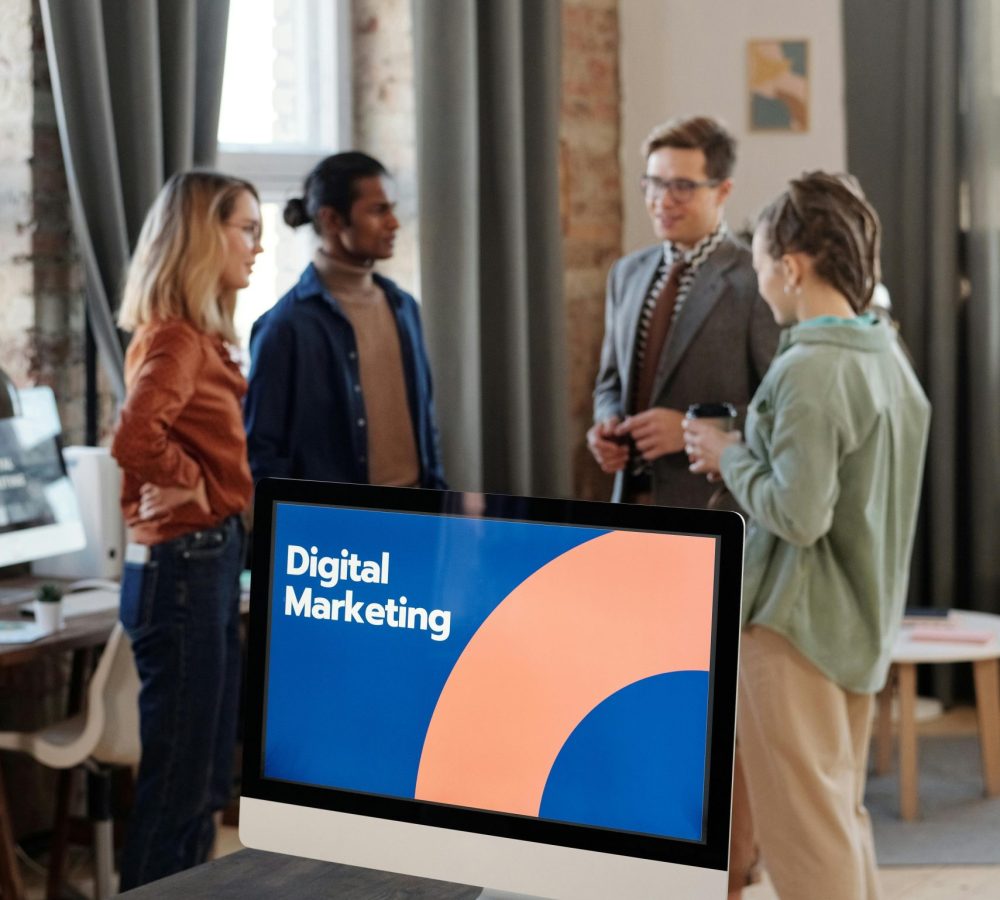 Business team engaged in a digital marketing discussion in a modern office setting.